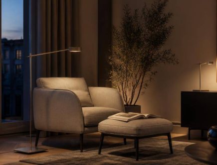 Soggiorno contemporaneo con lampada da lettura orientabile e illuminazione calda vicino a una poltrona.