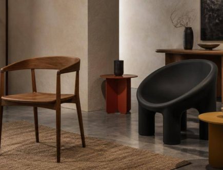 Sedute dalle finiture in legno e nero accostate a tavolini colorati in uno showroom.