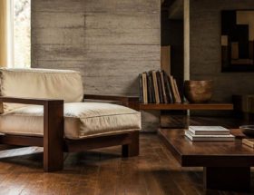 Poltrona dalle forme geometriche e dalle imbottiture generose in un soggiorno di ispirazione modernista.