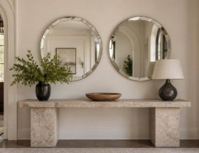 Due specchi circolari con bordo bisellato collocati in un ingresso elegante